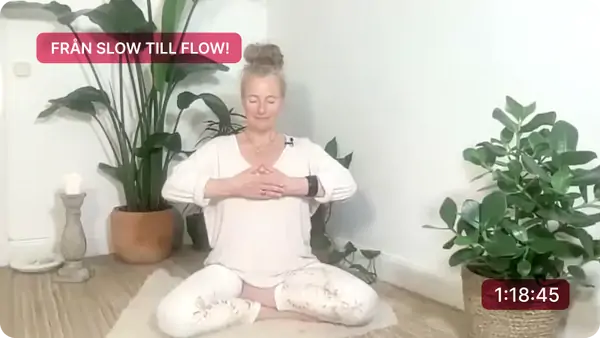Viveka leder en yoga class med mjuka sträckningar, omgiven av gröna växter i en lugn och harmonisk atmosfär.
